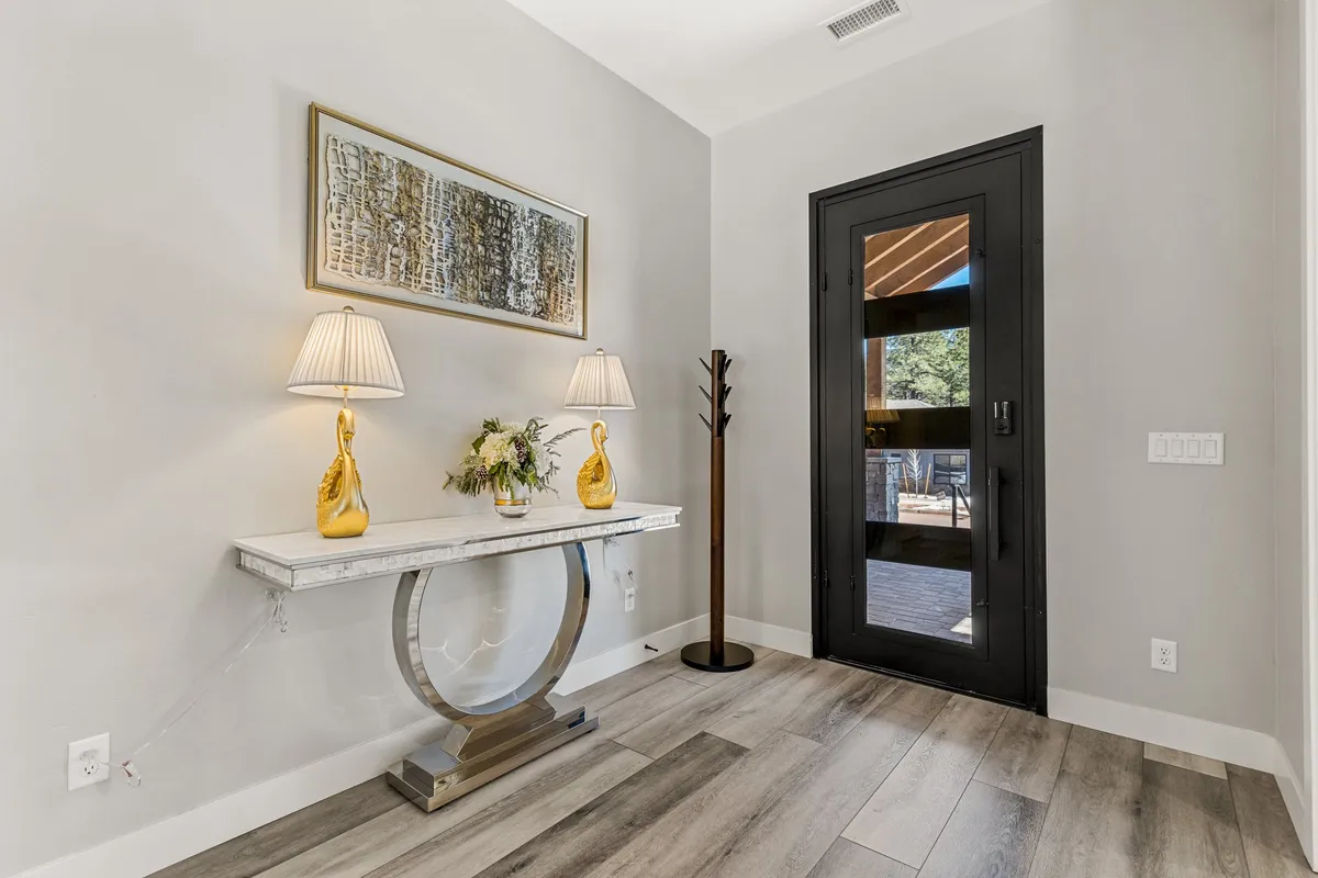 An inviting entryway with a console table, elegant table lamps, decorative art, and a view toward the front door. The space sets a welcoming tone for arrivals and departures, hinting at easy transitions between home and the surrounding neighborhood.